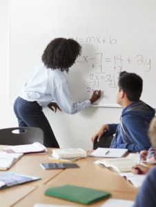 female-high-school-tutor-at-whiteboard-teaching-ma-2023-11-27-05-35-46-utc