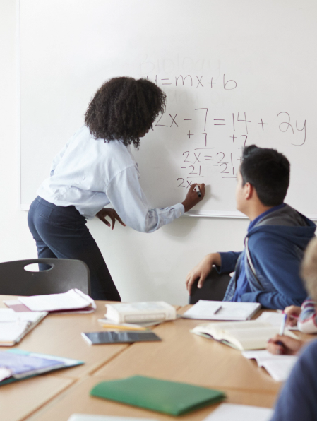 female-high-school-tutor-at-whiteboard-teaching-ma-2023-11-27-05-35-46-utc